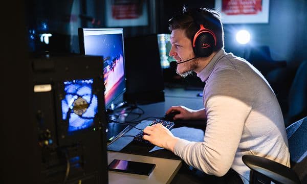 Mies pelaa pöytämallisella tietokoneella