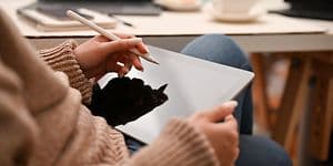 Kvinde holder en hvid pen over en tablet
