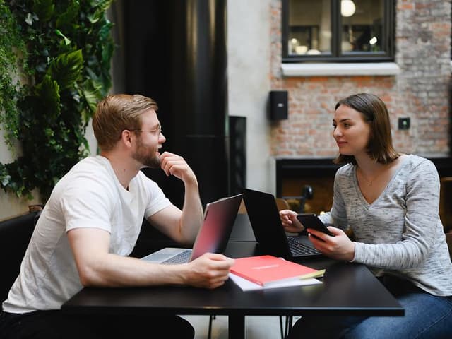 Man and woman working on laptops