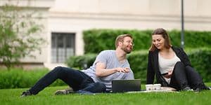 Mand og kvinde med laptop i en park