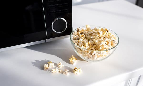 en microbølgeovn med en bolle popcorn ved siden av