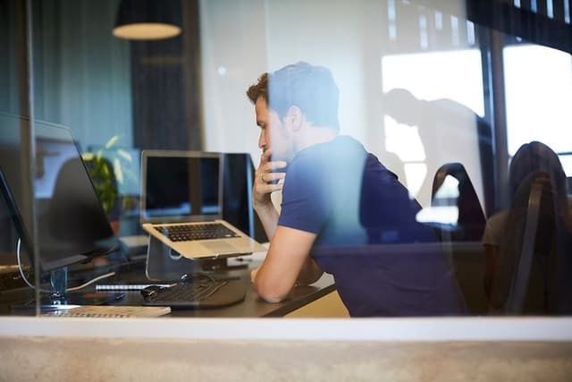 Mand sidder ved et skrivebord og arbejder på et kontor