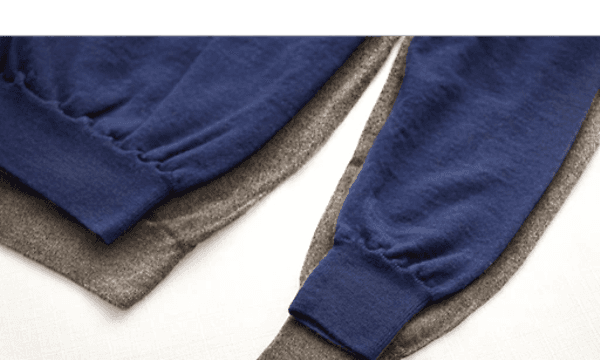 A blue shirt lying on top of a gray shirt