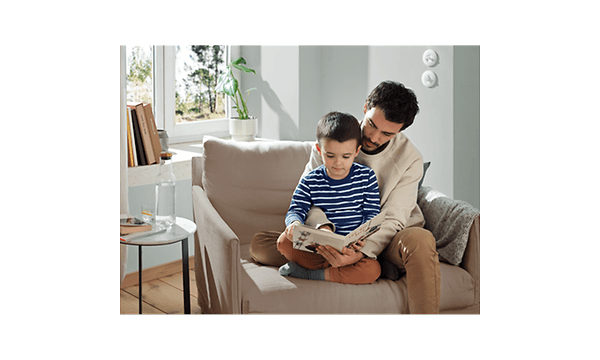 Man and child sitting in a chair reading