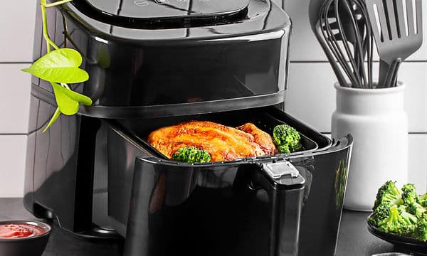 Åpen Airfryer med kylling og grønnsaker på et kjøkken
