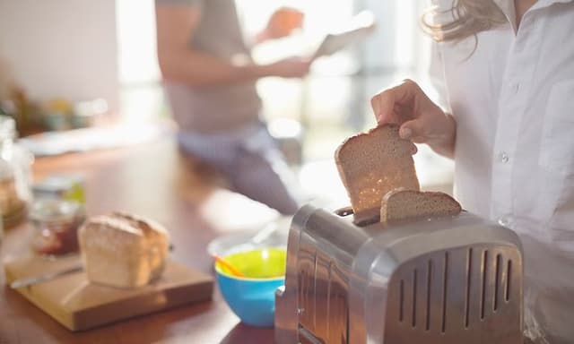 Ristet toastbrød tages op fra brødrister