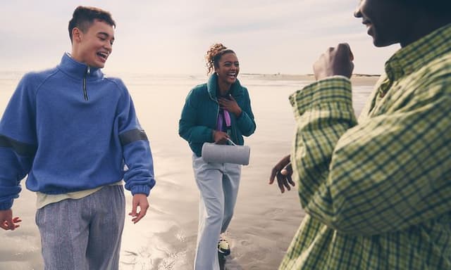 Unge mennesker på stranden med en Sony-højttaler