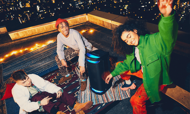 Unge mennesker på tagterrasse, der danser til lyden fra en partyhøjttaler fra Sony