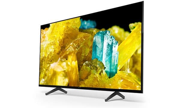 Sony-X90S TV-skärm som visar gula och turkosa ädelstenar och som står på ett stativ