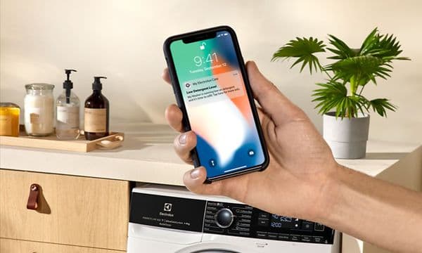 Hand holding a phone with a app notification from an Electrolux washingmachine