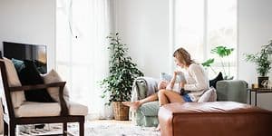 Kvinde og baby sidder på en sofa i stuen