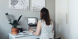 Kvinne jobber på laptop på lite hjemmekontor