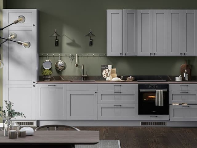 Epoq Shaker Light Grey kjøkken i åpen løsning mot olivengrønn vegg