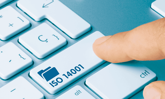Närbild av ett finger som trycker på en tangent på ett tangentbord för dator med texten ISO 14001