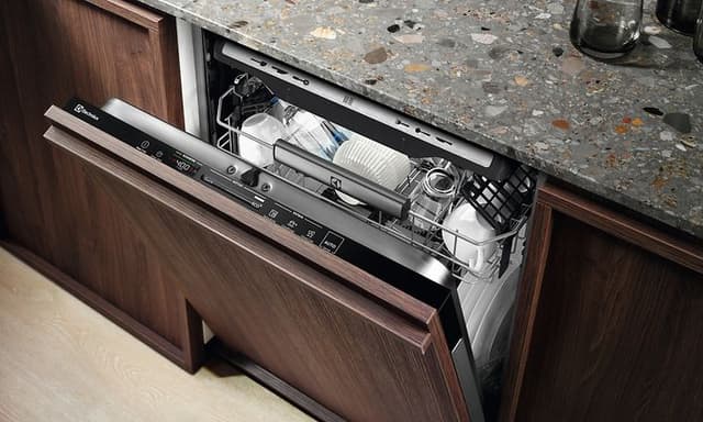En integrerad Electrolux diskmaskin med mörkt träfärgad och halvöppen lucka så att lite av disken inuti syns