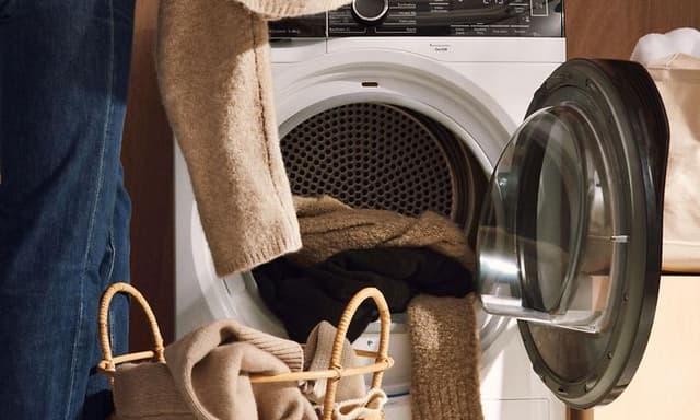 Person som legger tøyet i tørketrommel fra Electrolux