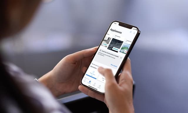 Hender som holder en smarttelefon