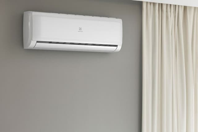 A wall mounted Electrolux heat pump next to a window