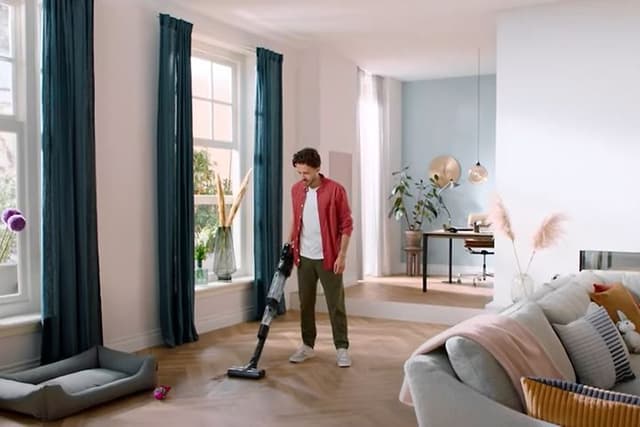 Mann rengjør og støvsuger med Philips AquaTrio