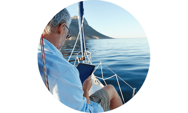 CS - Insurance - Man on a sailing boat with tablet