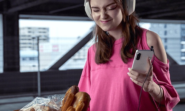 Nainen kuuntelee musiikkia kuulokkeista