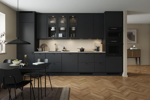 Black EPOQ Trend kitchen in an open kitchen solution with integrated oven, glass cabinet and dinner table
