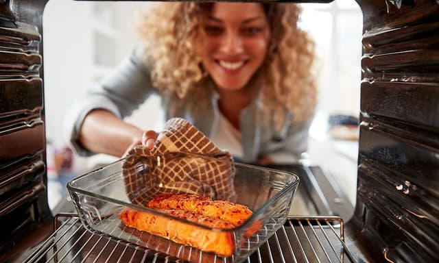 Woman cooks oven baked salmon
