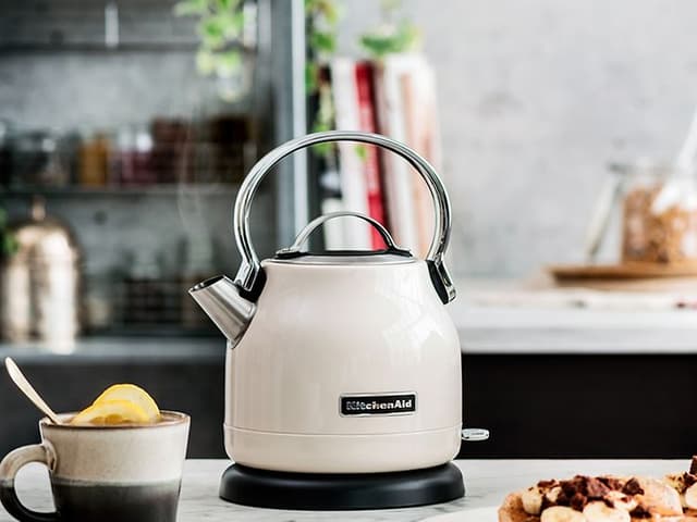 Valkoinen KitchenAid-vedenkeitin pöydällä