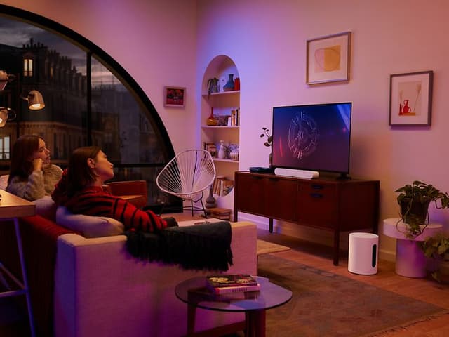 Folk ser tv med Gravity sub på gulvet