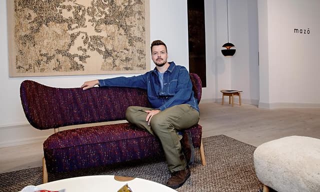 B2B - Mazo - Ejeren af Mazo i en designsofa foran logoet