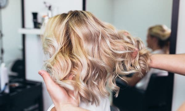 Kvinde med lyst krøllet hår i frisørsalon
