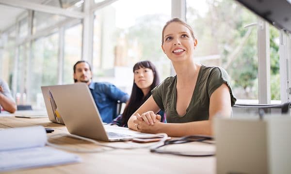 Mennesker på kontor som ser opp mot en TV