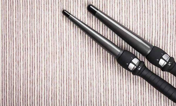 Two curling irons on a striped background