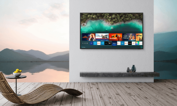 Samsung The Terrace Smart TV som henger på vegg utendørs på en platting ved havet