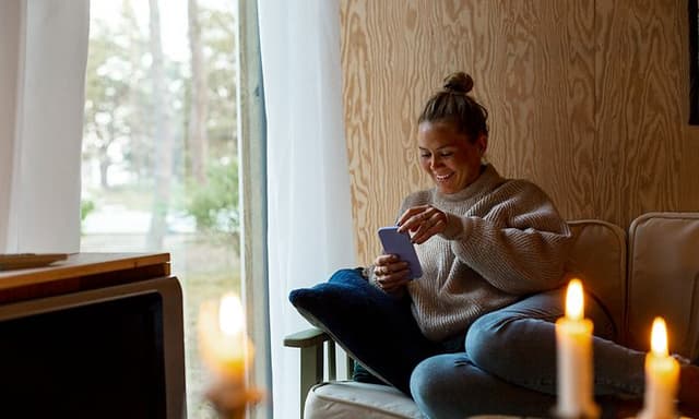 Kvinde i sofa med mobiltelefon
