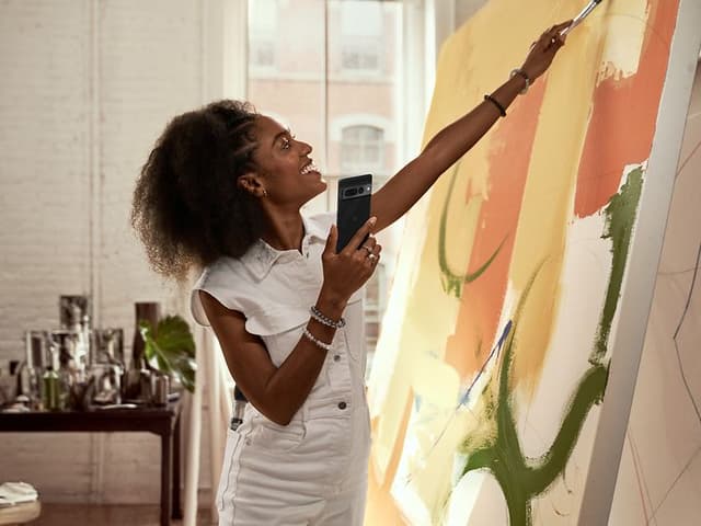 Kvinde maler, mens hun holder en Pixel-telefon