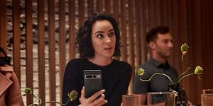 Woman in restaurant holding Pixel phone