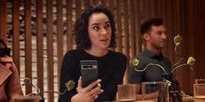Kvinde sidder på en resturant med sin Google Pixel 7 i hånden