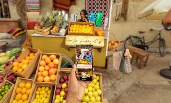 Käsi pitelee Google Pixel 7 Pro puhelinta ja käyttää Live Translate -kääntämistä kyltin kääntämiseen