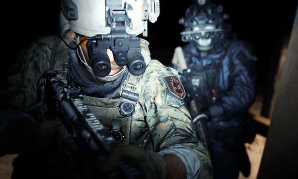 Skjermbilde fra Call of Duty Modern Warfare 2 med to menn i militærklær, spesialutstyr og våpen