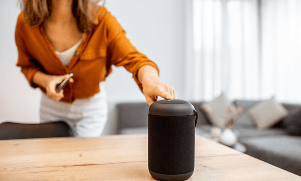 Display och mute funktioner: Kvinna som styr volymen manuellt på en smart högtalare.