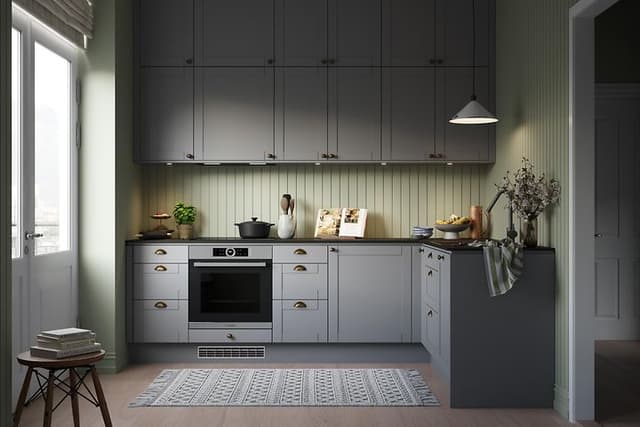 Epoq Shaker Steel Grey kjøkken mot lysegrønne vegger, overskap helt til taket, gulvteppe og altandør