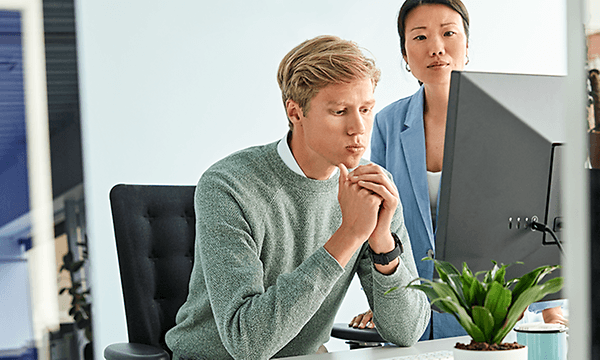 To kolleger på et kontor foran en pc 1000x500