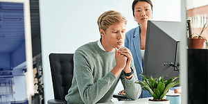 B2B - To kolleger på et kontor foran en PC 1000x500