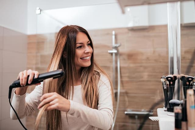 Woman using hair straightener