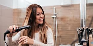 Woman using hair straightener