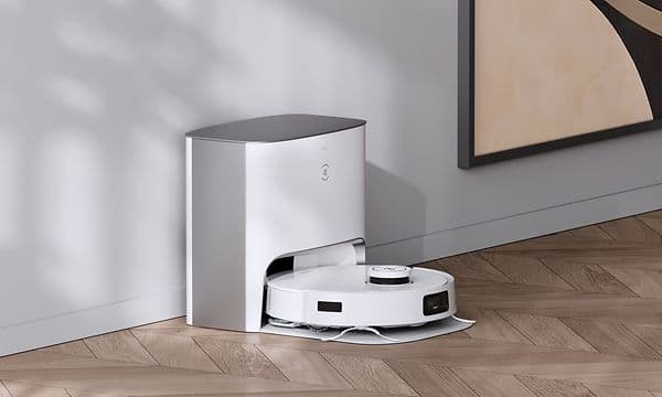T10 Plus i en tömningsstation på ett ljust trägolv bredvid en tavla
