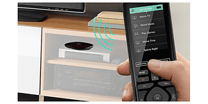 Hånd der betjener Logitech-fjernbetjening foran TV og medieafspillere