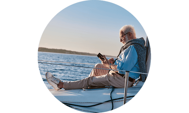 CS-Tablet and laptop insurance-Man sitting on a boat checking phone