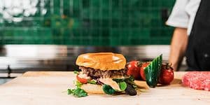 Burger with chef in the background